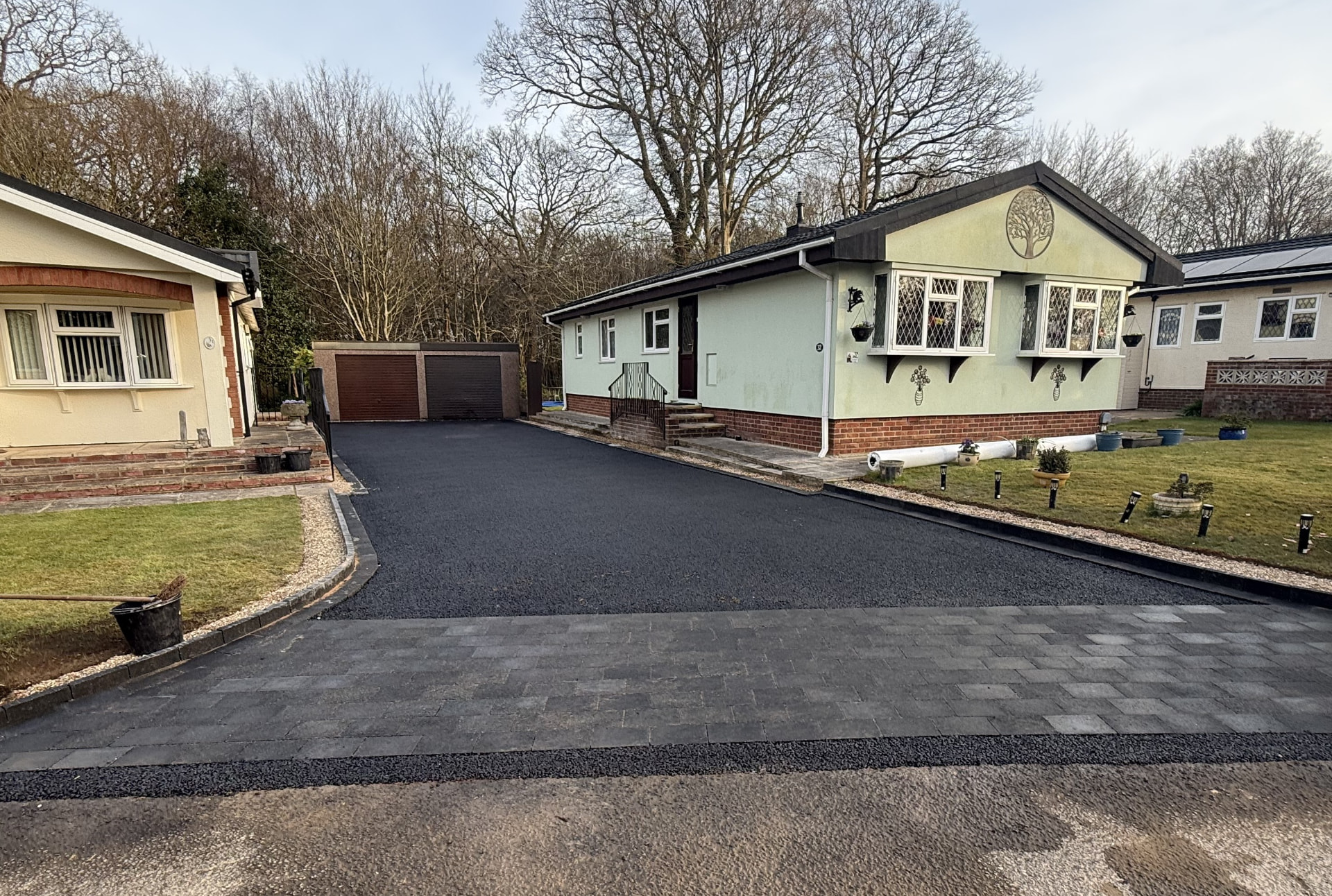 A Sussex home with a newly laid tarmac driveway and block paving border